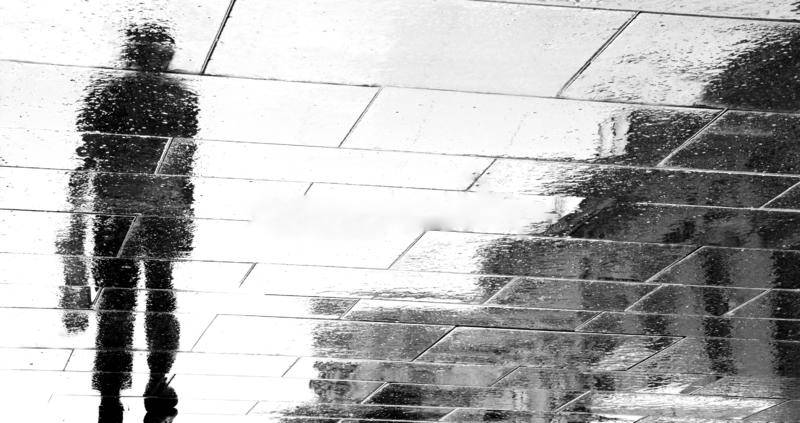 blurry reflection silhouettes man walking rainy day shadow dark city street black white 127594798 3